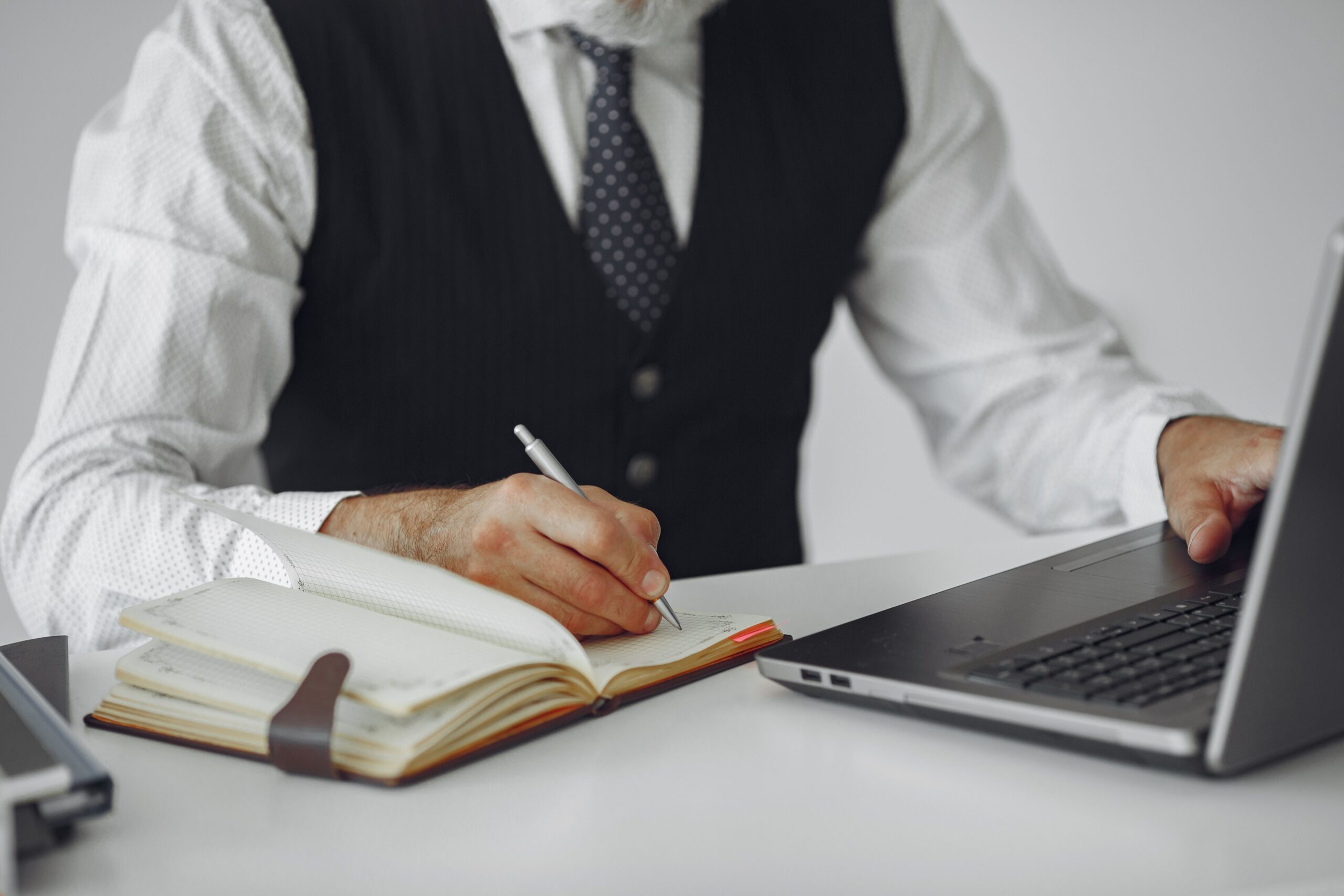شخص يطور مهاراته المهنية باستخدام الحاسب المحمول ويدون الملاحظات في بيئة عمل احترافية